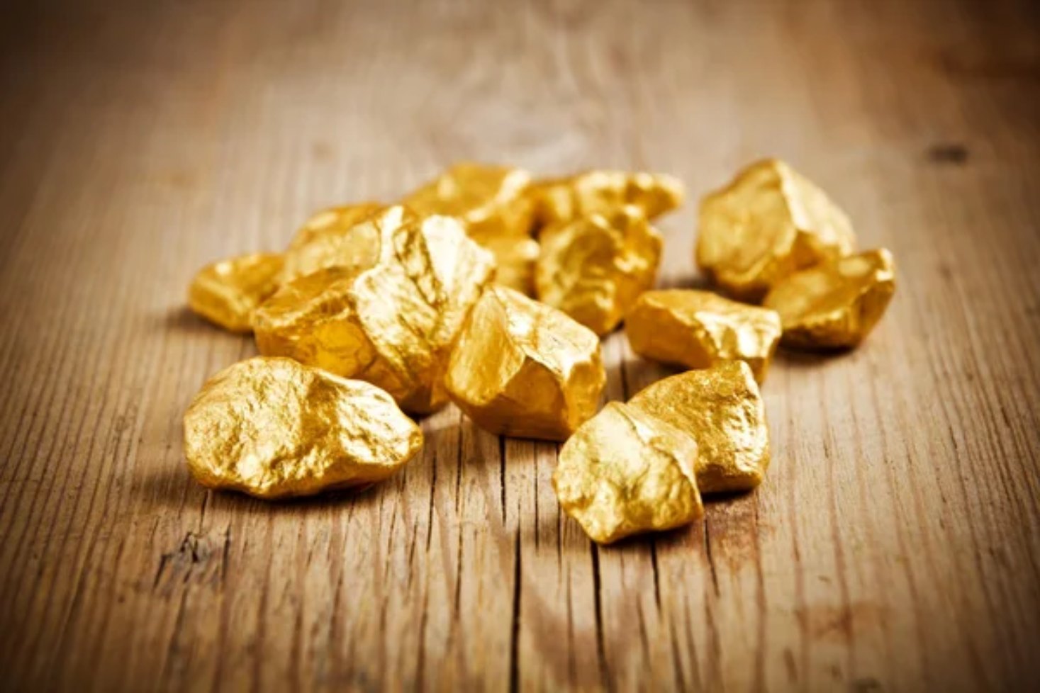 Gros plan sur un lingot d'or et des pièces d'or avec les tendances financières indiquées sur une feuille placée sous l'or.